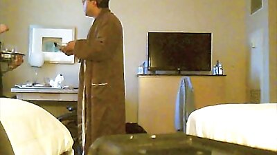 Täiskasvanud vanaema poseerib hotellis voodis kaamera ees